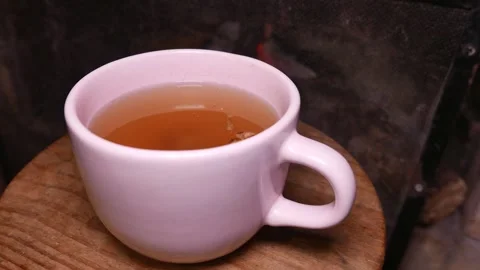 A teacup by the fireplace. Cup of ginger tea with honey. Cup of tea on a table Stock Footage 340380854