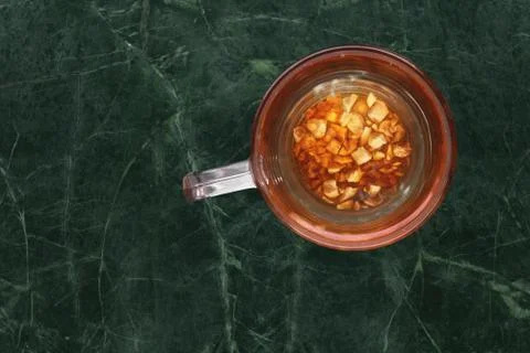 Teaglass with yellowhead root tea in a green   marble background Stock Photos