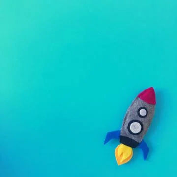 Teal Background with Handmade Felt Rocket Toy Stock Photos