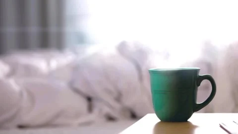 Teal Ceramic Coffee Mug with Steam on Wooden Bedside Table Video stock 337512444