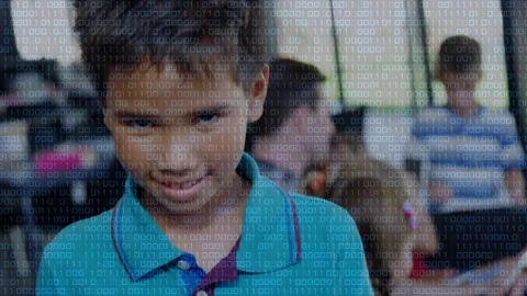 Teal-polo boy viewing tablet, shifting gaze forward and smiling, binary overlay Stock Footage 334351978