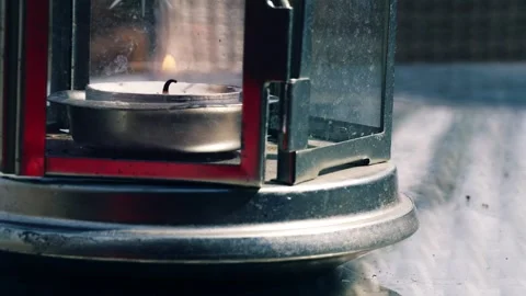 Tealight candle flame flickers in a lantern close up Stock Footage 241342541