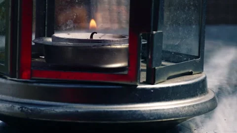 Tealight candle flame flickers in a lantern close up macro Stock Footage 244731375