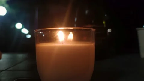 Tealight candle set on fire. Single candle flame on horizontal background. Stock Footage 217765197