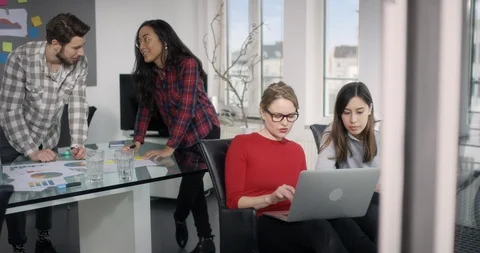 Team of 4 in a creative meeting working on papers and notebook in modern offi Stock Footage 91988346