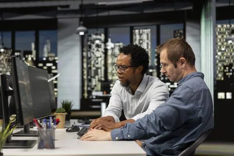 Team of admins coding on PC in startup office, refining machine learning models 写真素材