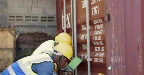 Team of African-American container workers use their laptops to inspect shipping Stock Footage 200859737