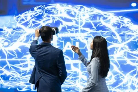 Team of AI startup technicians using VR headset to look at digital brain Stock Photos