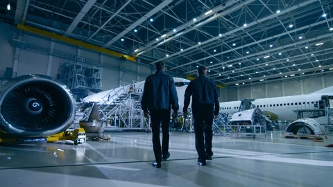 Team of Aircraft Mechanics and Engineers Waking Through Airplane Maintenance Stock Footage 106511201