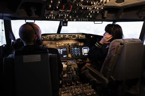 Team of airliner and captain using power switch on cabin dashboard Foto stock