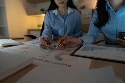 Team Analysis. Close-up of two professionals reviewing budget charts and data in Stock Photos