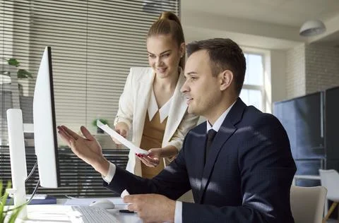 Team analysts discussing data dashboard on computer in bright modern office Stock Photos