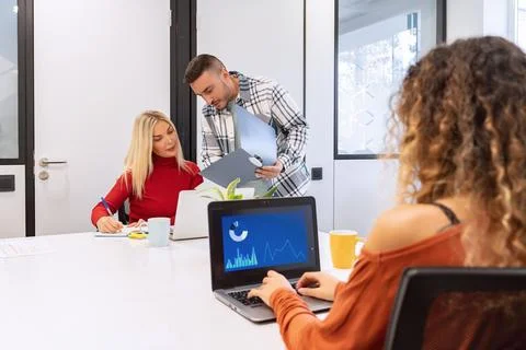 Team analyzing financial data on computer screens Foto stock