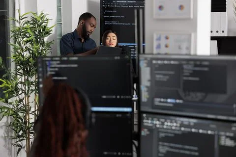 Team of app developers looking at coding algorithms on laptop Stockfoto's