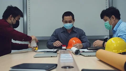 Team of architect and engineer wearing protective masks working in a office. Stock Footage 140458335