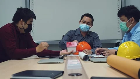 Team of architect and engineer wearing protective masks working in a office. Stock Footage 148150352