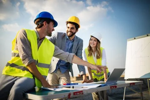 Team of architects and engineer in group on construciton site check documents Stock Photos