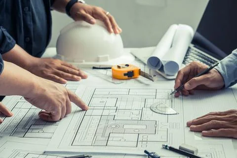 Team of architects and engineer working on construction plans Stock Photos