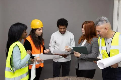 Team of architects and engineers having a meeting discussing blueprints Stock-Fotos