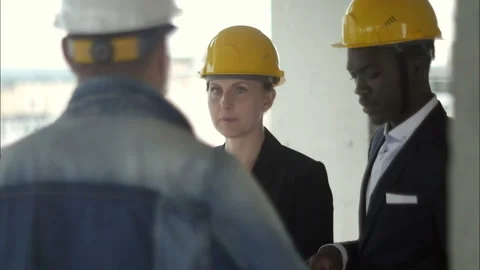 Team of architects comparing housing project with the building Видео 121287545