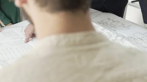 Team of architects examining blueprints, correcting and working together. Stock Footage 99984359