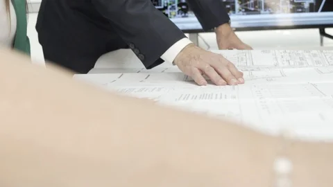 Team of architects examining blueprints, correcting and working together. Stock Footage 99984475