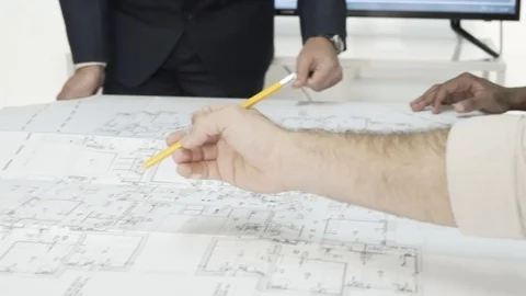 Team of architects examining blueprints, correcting and working together. Stock Footage 99984991