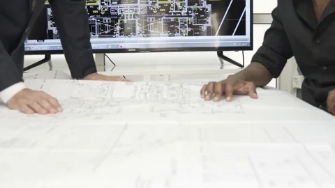 Team of architects examining blueprints, correcting and working together. Stock Footage 99985071