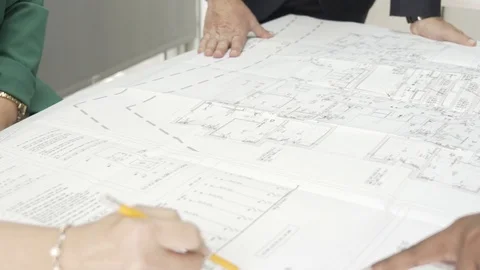 Team of architects examining blueprints, correcting and working together. Stock Footage 99985473
