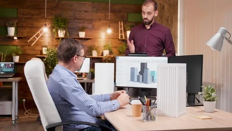 Team of architects in the office talking about design for the new city Stock Footage 115071569