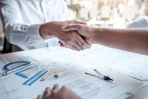 Team of architects or engineering shaking hands while working cooperation on Stock Photos