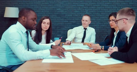 Team of architects sits around the table discussing construction plans Stock Footage 89208247