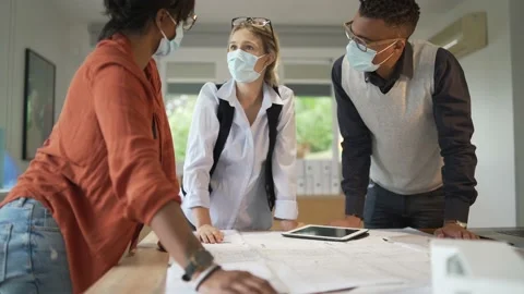 Team of architects working on project, wearing face mask in office Stock Footage 146574770