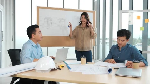 Team of Asian architects brainstorm working on blueprint in meeting room Видео 156484786