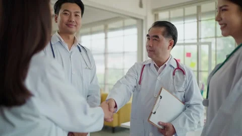 Team of asian doctors in white lab coat with stethoscope shaking hands together. Stock-Footage 274648904