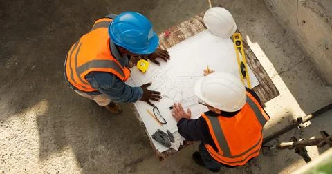 Team, blueprint and engineer at construction site for discussion, development Stock Photos