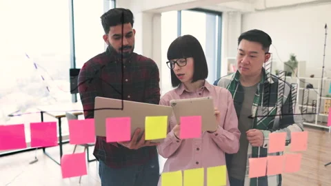 Team brainstorming session with sticky notes and graphs Stock Footage 284996774