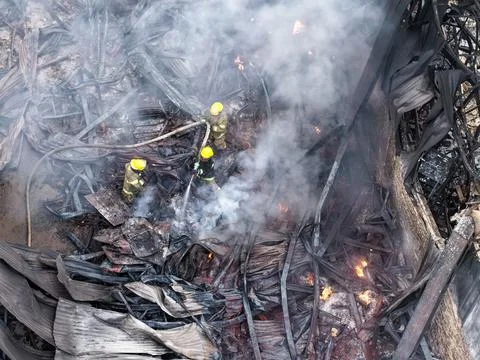 Team of brave firemen navigating through dangerous debris and smoke after a.. Stock Photos