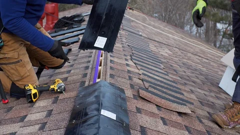 Team of builders attach soft tile and ridge on the roof. Frame house building Stock Footage 127756790