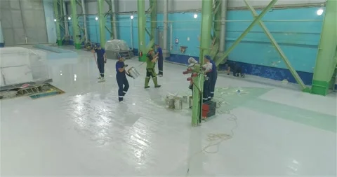 A team of builders makes heavy Duty Industrial Floor Coatings. A team of Stock Footage 282440741