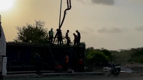 Team of builders working on a construction site during a golden sunset Stock Footage 337161207