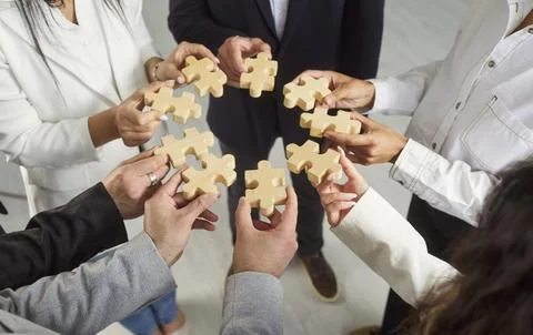 Team building and support, hands of business people group holding wooden puzzle Stock Photos