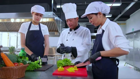 Team chef instruction and explaining apprentice about cooking and preparing.. Video stock 239251643