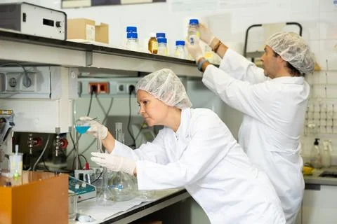 Team of chemists working in research laboratory performing experiments on lab Stock Photos