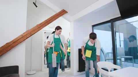Team of cleaning professionals working together in a modern living room to ensur Stock Footage 301514037