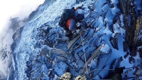 Team climbers coming down from the mountain in snow rock Stock Footage 115840790
