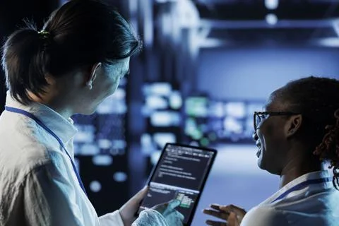 Team codes on tablet in data center Stock Photos