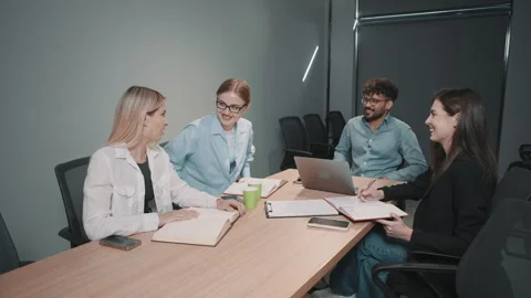 Team collaborates on document review in modern office setting with slow motion Stock Footage 312257023