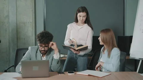 Team collaborates in office focusing on documents and discussions Stock Footage 312259967