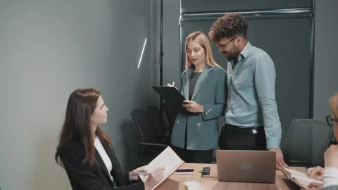Team collaborates in office setting to plan strategies and review documents Stock Footage 312257815